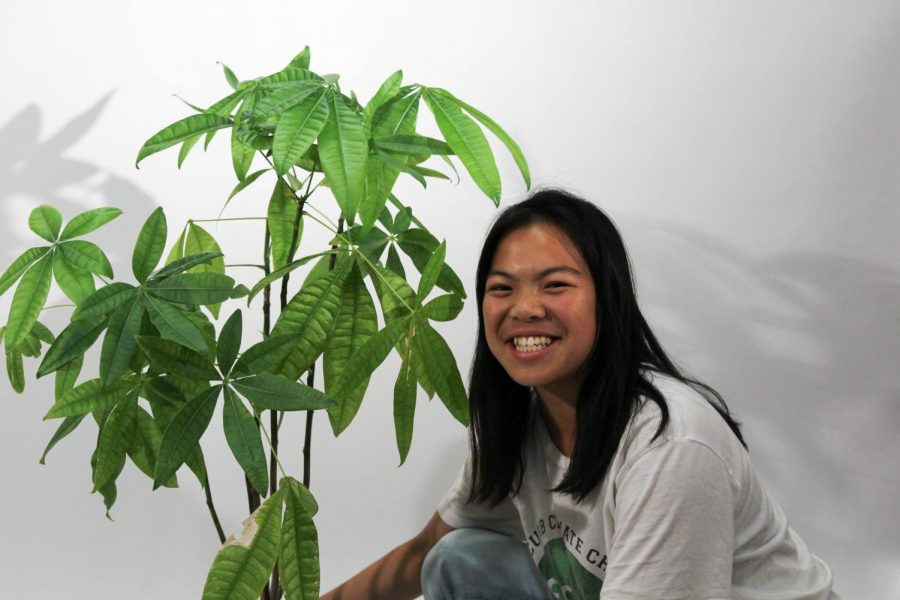 ECO Club president Kristen Tam poses by a plant