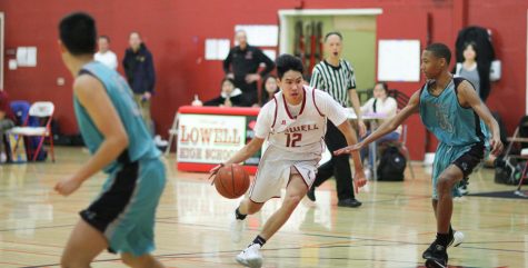 Sophomore forward Derek Quach fiercely dribbles down the court during the game against the Burton Pumas on Jan. 14 at home.
