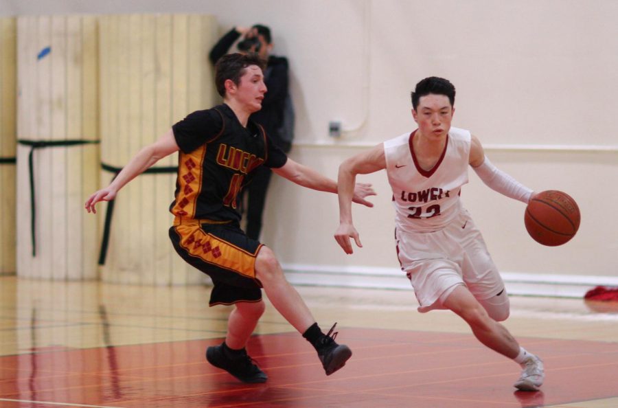 Agilely staving off from his opponents defense, junior point guard Nathan Ly dribbles furiously down the court.