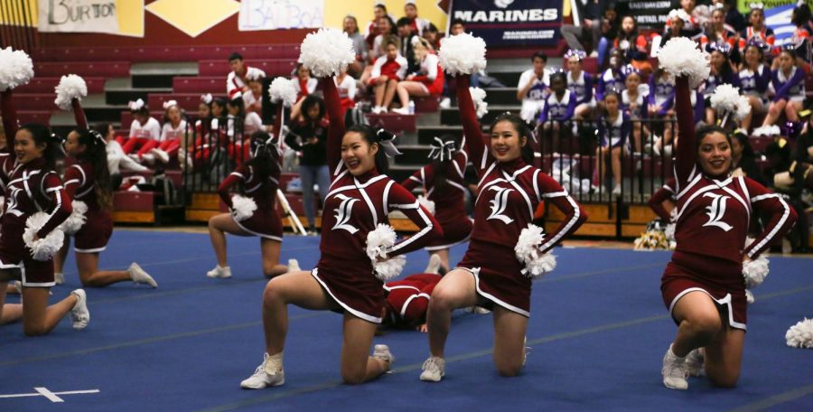 Freshman Alice Eng, juniors Gigi Huang and Darcy Munoz hold up their pom-poms at the end of their dance routine.