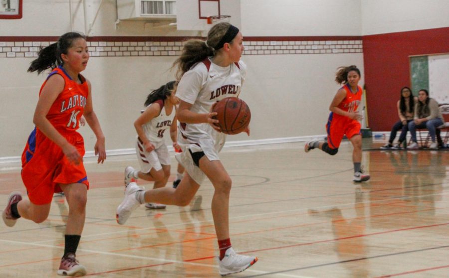 Freshman point guard Elle Ladine strives to drive down the court toward the  opponents basket.  