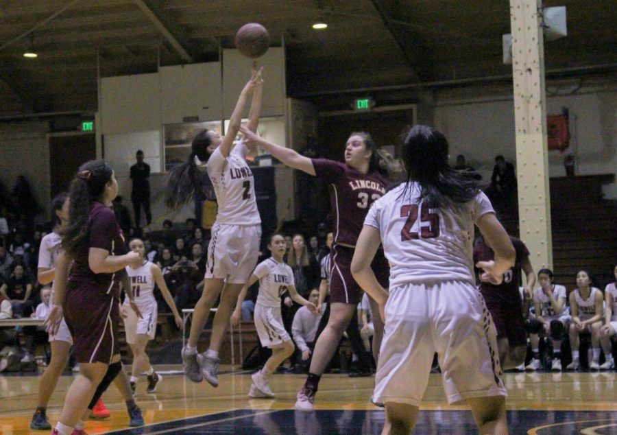Senior KD Lee takes a shot at the basket as a Mustang tries to block her.