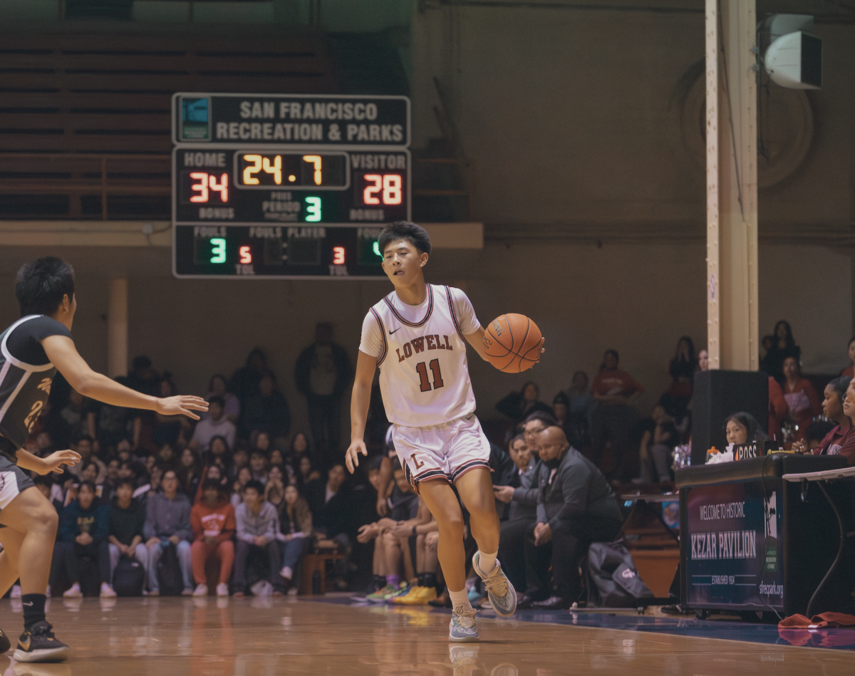 Sophomore Jalen Ly (11) dribbles down the court.